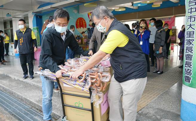 台中市大里家长会长协会结合大里区立仁里长郑伯其的爱心，6日在内新国小举办屯区25所学校物资及教育基金联合捐赠仪式，受赠学校开心将物资搬回学校。（黄国峰摄）