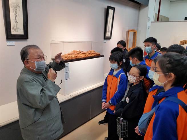 国宝级雕刻大师张敬（左一）为北港国中学生导览最新作品「青山绿水-天佑台湾」。（周丽兰摄）
