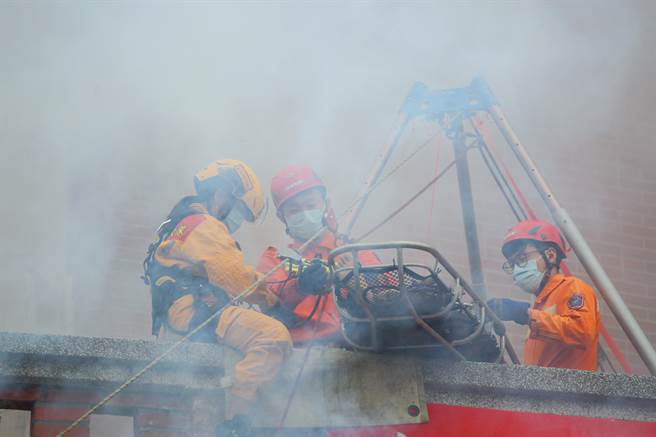 「2022臺北年貨大街消防演習」，圖為模擬民眾在高樓受傷，搜救隊出動籃式擔架進行援救。（張鎧乙攝）