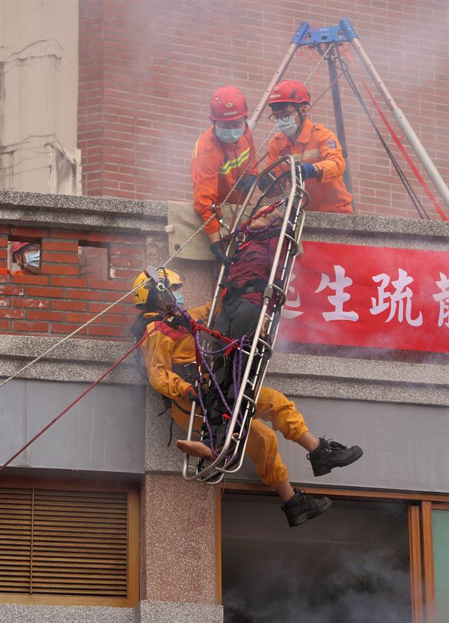 「2022臺北年貨大街消防演習」，圖為模擬民眾在高樓受傷，搜救隊出動籃式擔架進行援救。（張鎧乙攝）
