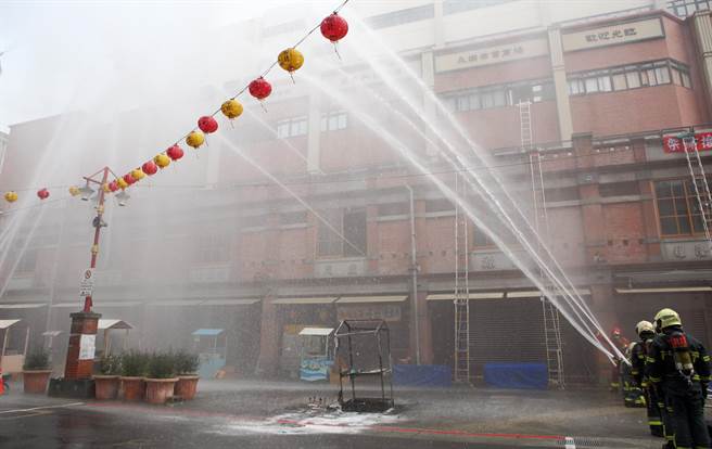 「2022臺北年貨大街消防演習」，圖為模擬年貨大街發生火警，消防人員布水線搶救。（張鎧乙攝）