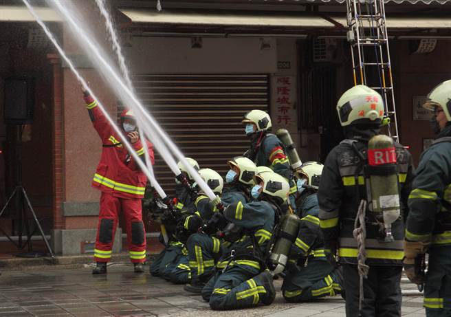 「2022臺北年貨大街消防演習」，圖為模擬年貨大街發生火警，消防人員布水線搶救。（張鎧乙攝）