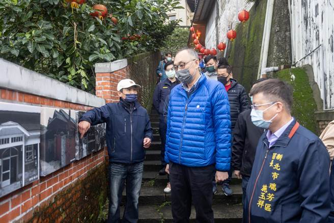 金瓜石在地导览员张传益向谢政达解说矿山共学基地修改前后的老照片。（黄金博物馆提供）