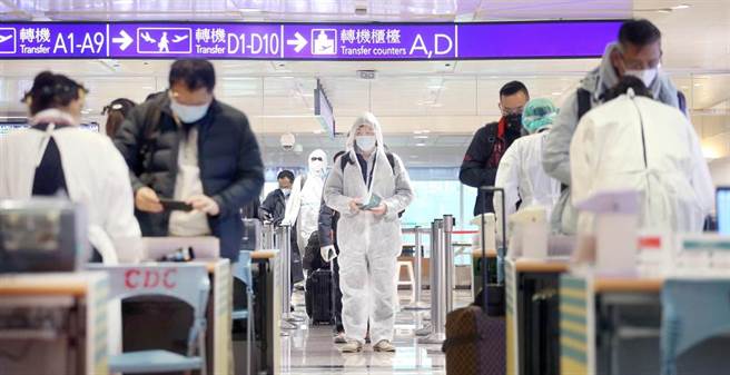 在桃園機場入境管制區內，剛下機的旅客排隊查驗入境檢疫資料。（范揚光攝）
