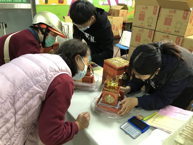 幸运中籤买主仔细检查「玉玺酒」，货物出门概不退换。（李金生摄）