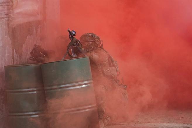 陆军步兵训练指挥部学员在城镇战训练中，扮演红军官兵在烟雾弹掩护下攻击前进。（黄子明摄）