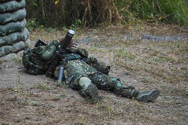 一名陆军步兵训练指挥部学员在演习中模拟遭枪击战亡；国军引进「实兵模拟接战系统」，在士兵枪管、钢盔与服装上装设高科技感测仪器，训练中可模拟遭受枪击战损情况。（黄子明摄）