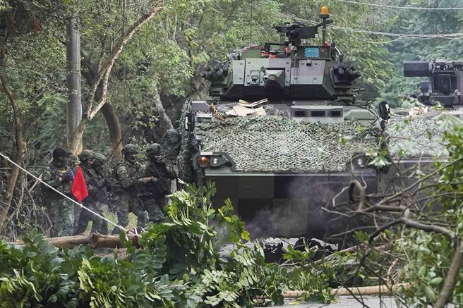 陆军步兵训练指挥部学员6日在城镇战训练中，扮演红军官兵在装甲车及烟雾弹掩护下，穿越障碍物攻击前进。（黄子明摄）