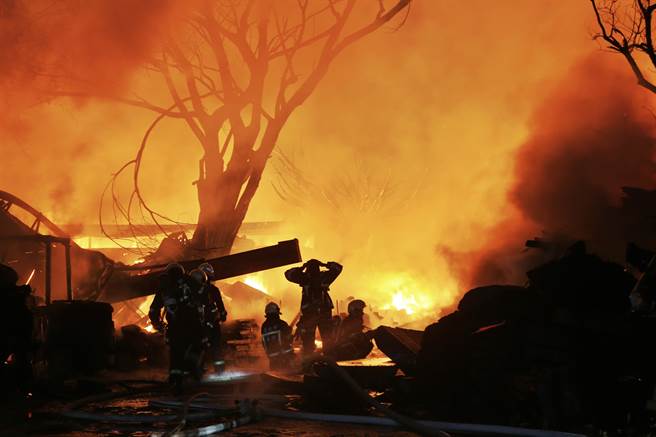 警消赶抵现场时，木材厂已全面燃烧，消防人员立即布下多道水线制止火势延烧。（杜宜谙摄）