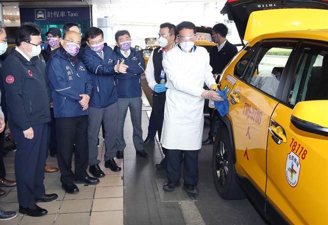 桃園機場群聚感染升溫之際，行政院長蘇貞昌（左二）8日在衛福部長陳時中（左四）、交通部長王國材（左三）及桃園市長鄭文燦（左一）等人陪同下視察桃園機場防疫措施，並了解防疫計程車的消毒流程，針對疫情蔓延，蘇貞昌表示確診病例都有軌跡可循，都在掌控之中。圖非確診當事人。（范揚光攝）