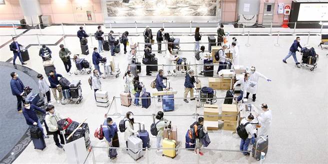 在桃機第二航廈入境大廳內，旅客準備前往採檢站。（范揚光攝）
