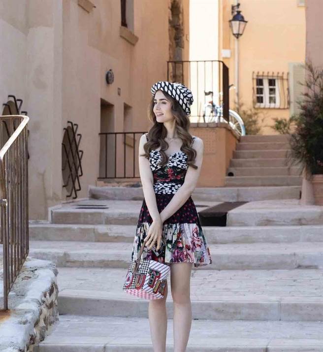 莉莉柯林斯以Dolce &amp; Gabbana印花连身裙、Christian Louboutin手提包、Marimekko渔夫帽，呈现渡假风情。(翻摄自Emily in Paris IG)