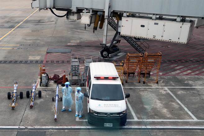 1日即将实施的长程航班旅客COVID-19落地採检作业新规定，若旅客在入境採检时确诊，将由在空桥下等候的救护车送医。（陈麒全摄）