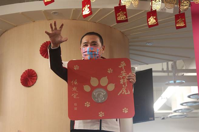 新北小福袋外袋充满老虎斑纹，侯友宜说，虎纹台语谐音为「好运」，象徵虎年「好运满满」，还示范虎爪会把钱抓进来，赚大钱。（陈慰慈摄）