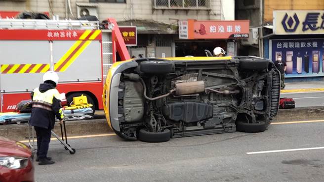 台北市萬華區西園路口和艋舺大道今（10）下午發生1輛計程車因不明原因失控暴衝，先是撞擊1輛黑車的左後方後再一路衝向中央分隔島後翻覆在路中。（記者張達智拍攝）