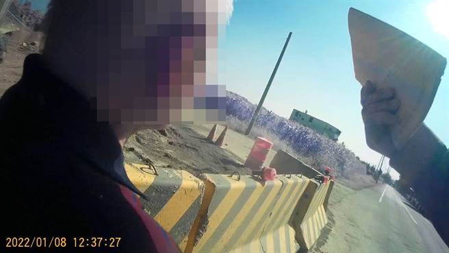 警員湯銘輝趕抵現場，從老翁的外觀，似乎曾協助這名走失老翁返家，於是拿出隨時攜帶的筆記本，並耐心詢問老翁，終於確認老翁身分。（讀者提供／張毓翎台南傳真）