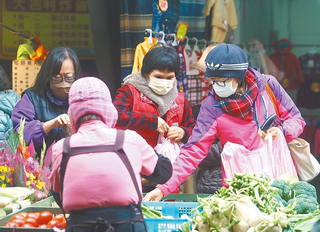 隨Omicron疫情擴大至社區，學者專家認為，若本土疫情再起，這波餐飲業的漲勢可能暫時停歇。圖為桃園忠貞市場攤商與採買民眾皆戴上口罩。（陳怡誠攝）