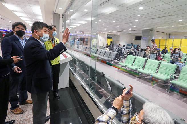 長程航班落地採檢11日登場，指揮官陳時中在桃機前進指揮所指揮官王必勝等人的陪同下，在入境長廊隔著玻璃視察候機室內的採檢作業。（陳麒全攝）