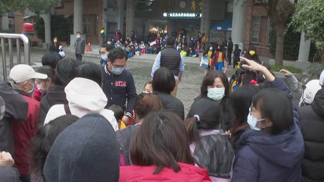 桃園市中壢區某國小附設幼兒園有學生確診，校方下午全面停課，校門口塞爆家長趕著接孩子回家。（賴佑維攝）