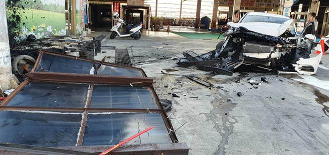 賓士車車頭撞爛，零件四散一地，廣告店招也被撞爛，現場一片狼藉。（謝瓊雲攝）