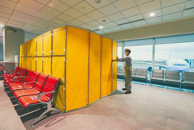 長程航班旅客今起規定落地需採檢新冠病毒，桃園國際機場工作人員昨日忙著在候機室內搭起採檢空間。（陳麒全攝）