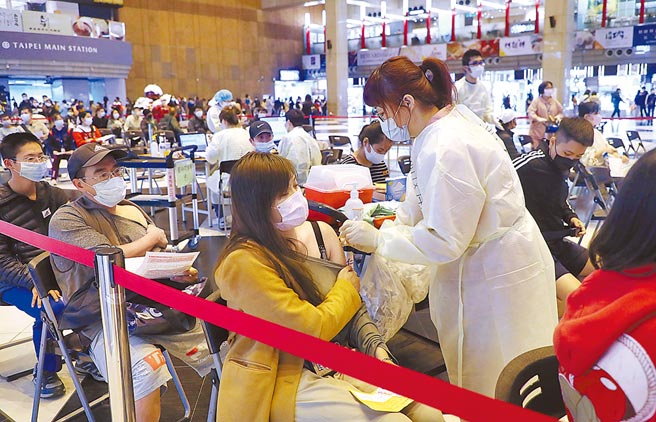 國內疫情升溫，民眾接種疫苗意願提高，醫護人員依序幫前來台北火車站接種站的民眾施打疫苗。（劉宗龍攝）