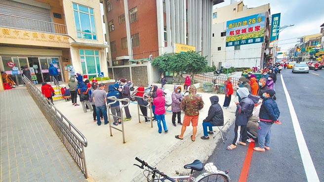 桃园机场群聚让疫情升温，位处「重灾区」的桃园掀起疫苗抢打潮，像是大园卫生所10日晚间6点开设夜间门诊，午后就见排队人龙，有人自备椅子、有人看书、有人埋头滑手机。（蔡依珍摄）