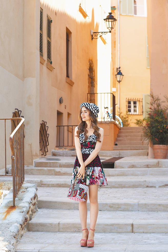 莉莉柯林斯以Dolce & Gabbana印花連身裙、Christian Louboutin手提包、Marimekko漁夫帽，呈現度假風情。（摘自Emily in Paris IG）