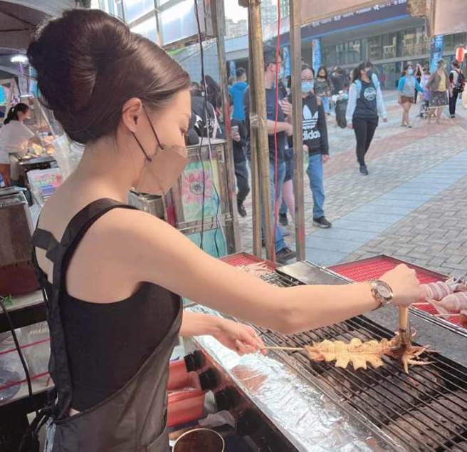 白皙皮肤的正妹老板娘在认真烤小卷。(翻摄自 爆废公社二馆FB)