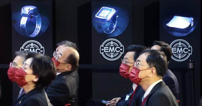 在揭牌仪式会场旁，投影机展示我国自主研发的电子脚环（左起）、电子手环及居家读取器。（范扬光摄）
