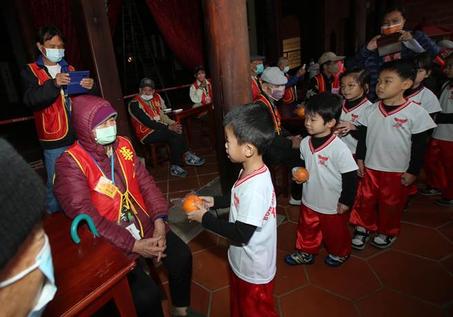 華山基金會12日在有百年歷史的霧峰林家宮保第園區舉辦「千歲揮毫」活動，台電志工隊，為長輩們奉上熱茶及贈送暖暖包。（黃國峰攝）