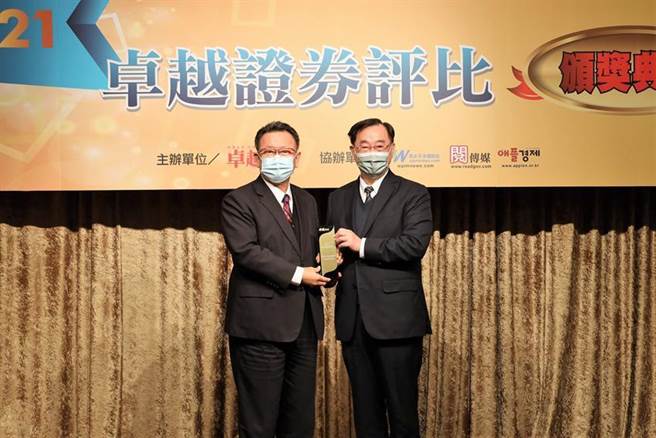 （群益金鼎证券总经理贾中道(左)从证交所董事长许璋瑶手中接下「2021卓越证券评比」的「非金控类-最佳券商奖」奖座。图／群益金鼎证券提供）