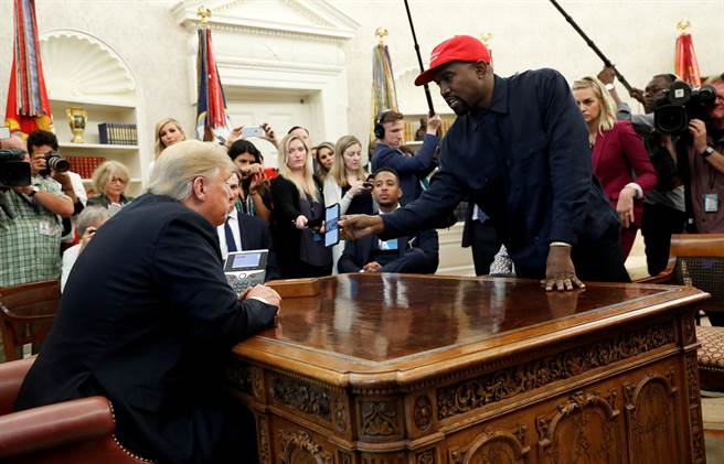 2018年10月11日，饒舌歌手肯爺(Kanye West)在白宮向川普(Donald Trump)展示了他的手機。(圖/路透社) 