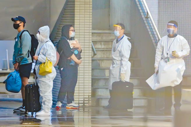 長程航班落地採檢新制實施首日，首架抵台的航班有4人（3成人、1嬰兒）確診，4人由專人引導至機坪，在風雨中等候超過10分鐘，才有工作人員引導上救護車。（陳麒全攝）