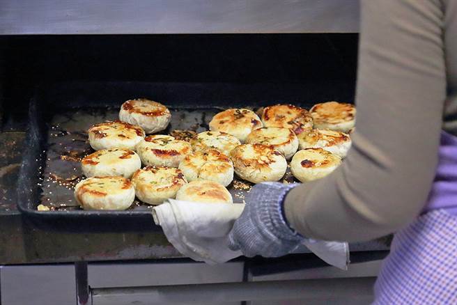 铁盘上热腾腾出炉的猪肉馅饼，内馅是爆满葱花和咸香猪肉，滋味令人惊艷。(摄影/Carter)