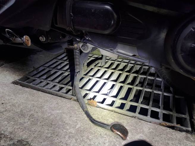 24歲楊姓女子日前在新北市中和區景新街準備騎機車時，卻發現機車中柱卡進水溝蓋裡，中和警分局警員協助排解。（中和警分局提供）