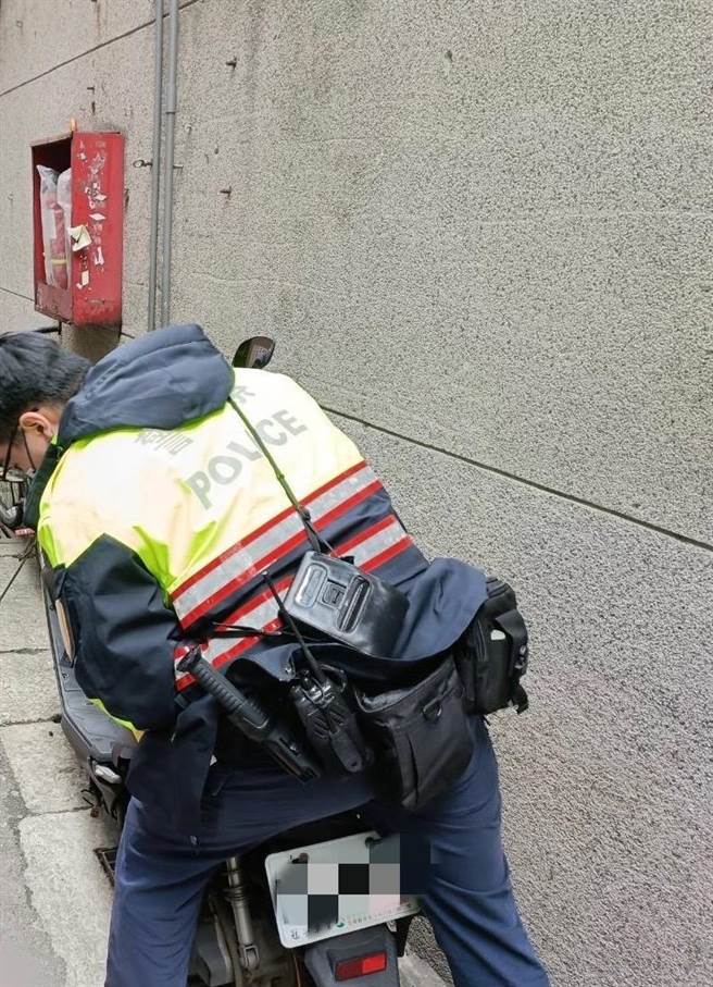 24歲楊姓女子日前在新北市中和區景新街準備騎機車時，卻發現機車中柱卡進水溝蓋裡，中和警分局警員協助排解。（中和警分局提供）
