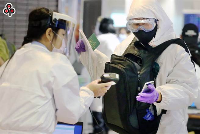 新冠肺炎疫情升溫，在桃園機場入境管制區內，長程航班旅客採檢確認陰性反應後，排隊查驗入境檢疫資料。（本報資料照片）