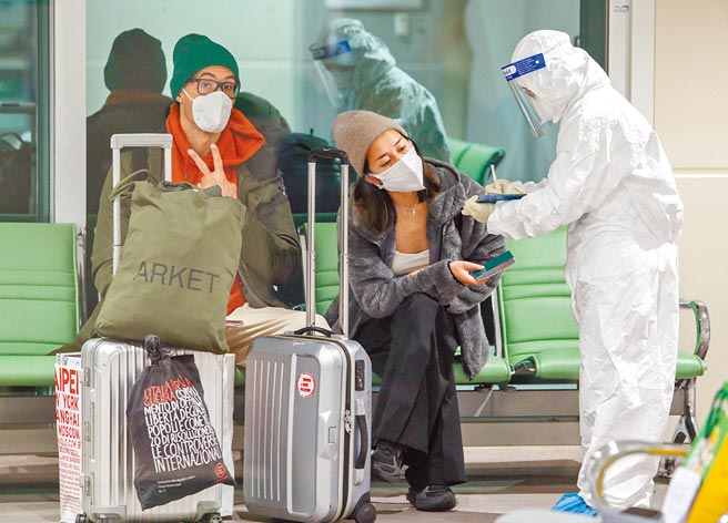 长程航班旅客须在机场採检阴性，才放行入境，旅客在下机后进入候机室，等待疾管署人员核对名单，在唱名后先贴上检疫视别贴纸，再依序採检、等待结果。（陈麒全摄）