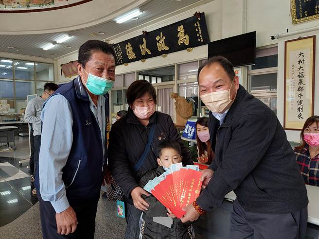 大村鄉大村村張小姐（中）帶著孩子來為全家人領走8個大紅包，右為大村鄉長游盛、左為鄉代會主席游振府。（謝瓊雲攝）