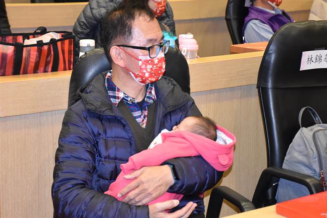 竹南虐杀幼儿事件，涉案印尼外配所生2个月大男婴，安详地躺在寄养家庭林爸爸怀里。（谢明俊摄）