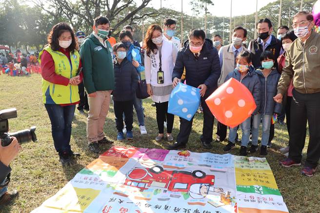 黃偉哲（左五）和小朋友玩防災宣導大富翁遊戲。（劉秀芬攝）