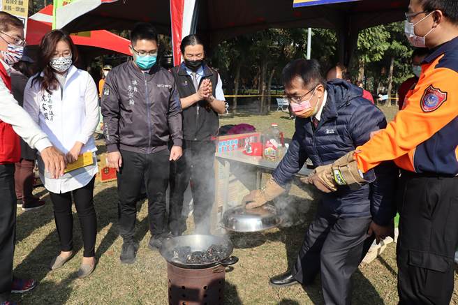 黃偉哲（右二）體驗正確油鍋滅火步驟。（劉秀芬攝）