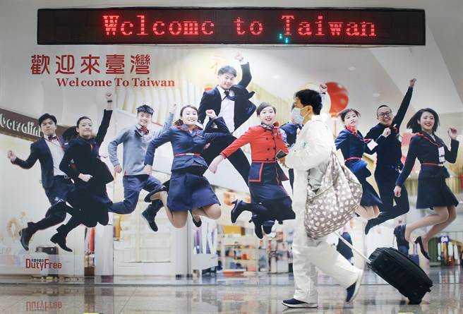 新冠肺炎疫情逐漸升溫，在桃園機場入境管制區內，剛下機的旅客準備通關入境。（范揚光攝）