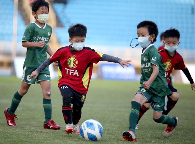 安聯小小世界盃U6組冠軍戰，TFA劉家睿（左二）帶球突破旅人發電機鄭安鈞（右二）的防守。（李弘斌攝）