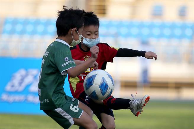 安聯小小世界盃U6組冠軍戰，TFA隊長高佳駒（右）右腳射門，旅人發電機詹亞諾奮力阻擋。（李弘斌攝）