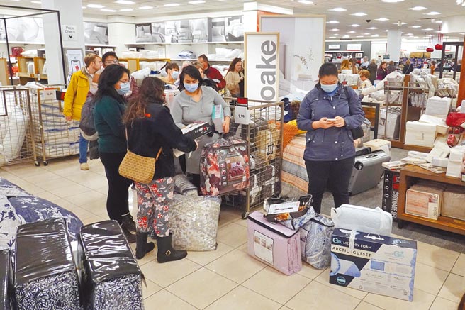 高传染力的Omicron新变种病毒肆虐美国，12月的新增确诊案例创下新高纪录，打击2021年年终销售。图／美联社