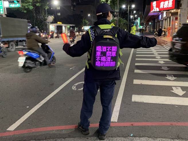 高雄三民第一分局员警利用LED背包吸引行人及驾驶的目光。于执行交通疏导勤务时，进行反酒驾交通宣导，相当吸睛。(三民一分局提供)