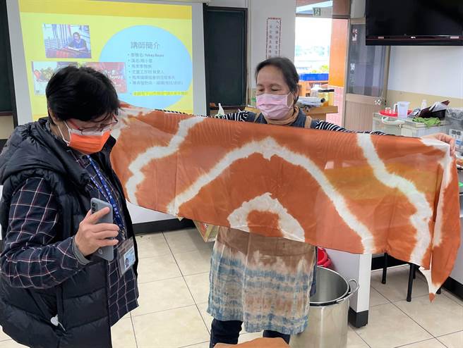 泰雅族织女周小云老师(右一)应邀前来传授技艺，完成植染作品后，庄敬高职余姮老师(左一)马上开心拍照纪录。(新北市原住民族行政局提供)