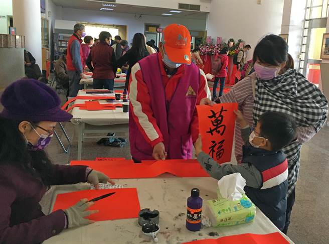 不少家长带着小朋友，全家总动员到场赏字，也帮忙晾乾春联墨汁，上了一堂不一样的亲子书法课。（李金生摄）